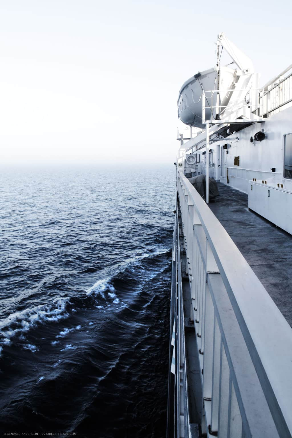 The side deck of a ferry boat, with the lake water extending to the horizon.